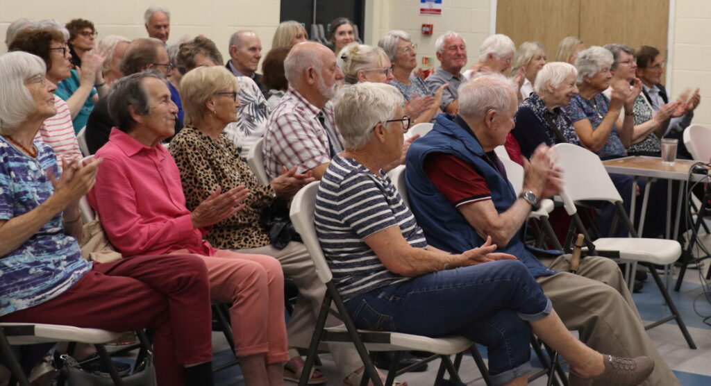 Members applauding at monthly meeting